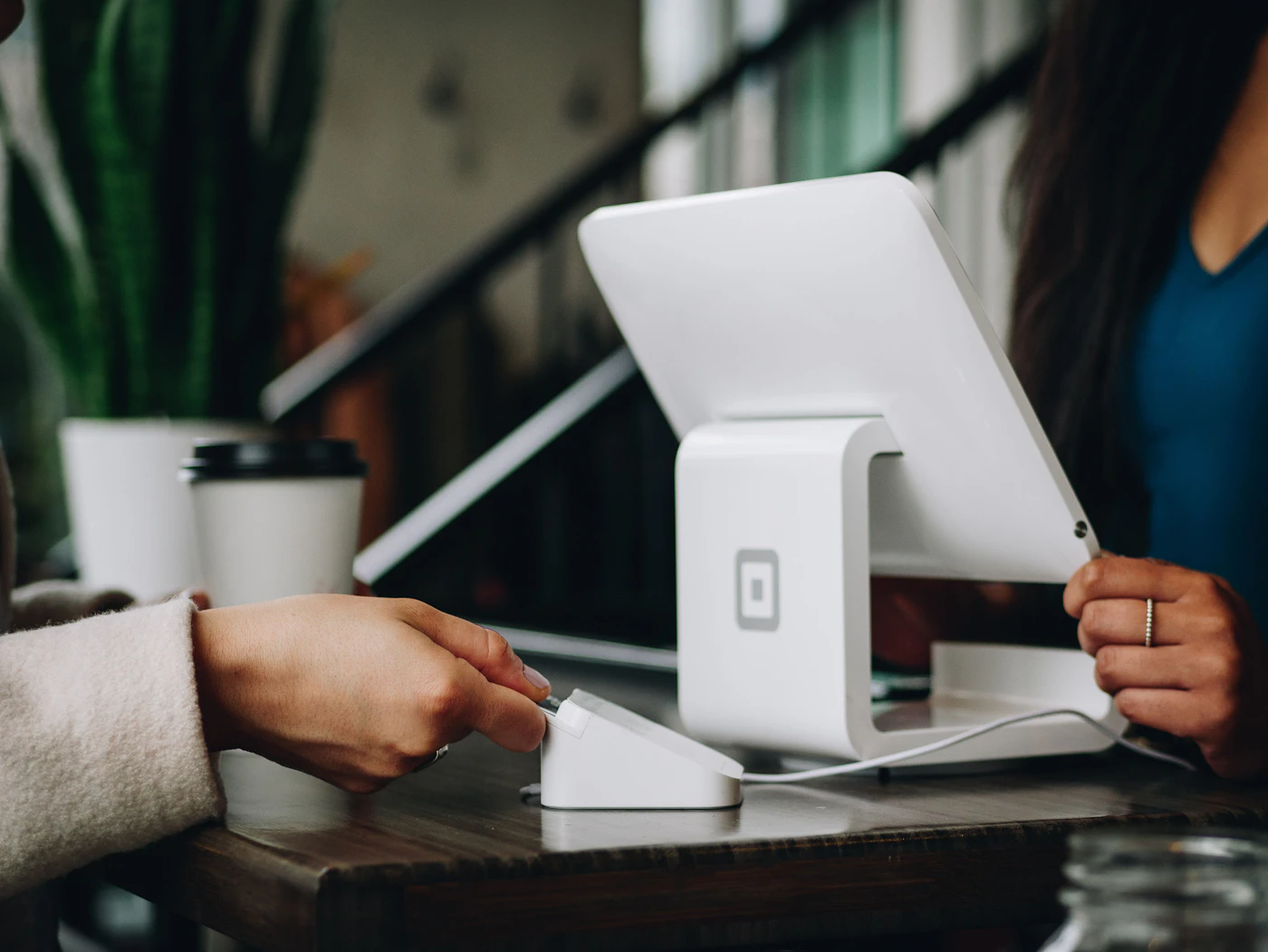 Customer paying at a café counter tablet